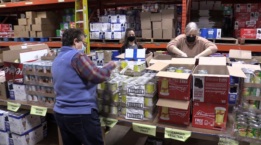 Volunteers sort food at the London Food Bank just days ahead of the wrap up of the London Business Cares Food Drive, Dec. 18, 2021. (Brent Lale / CTV News)