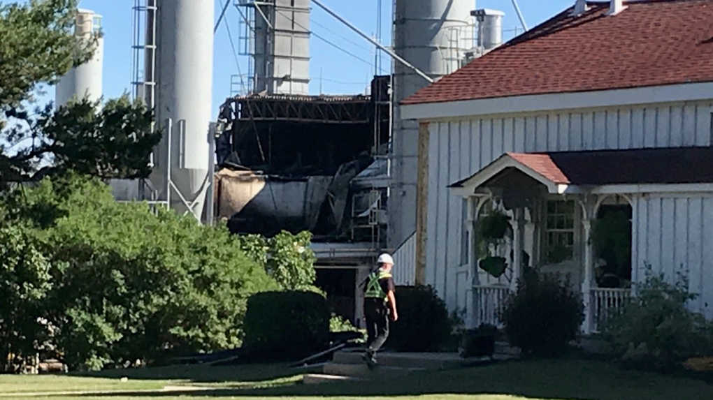 An employee walks towards a historic farm house located just in front of a fire-damaged portion of the Coldstream Concrete facility in Middlesex County, Ont. on Wednesday, June 16, 2021. (Sean Irvine / CTV News)