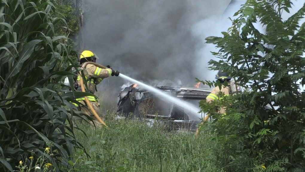Firefighters douse the flames after a two-vehicle crash in south London, Ont. on Wednesday, Aug. 11, 2021. (Bryan Bicknell / CTV News)