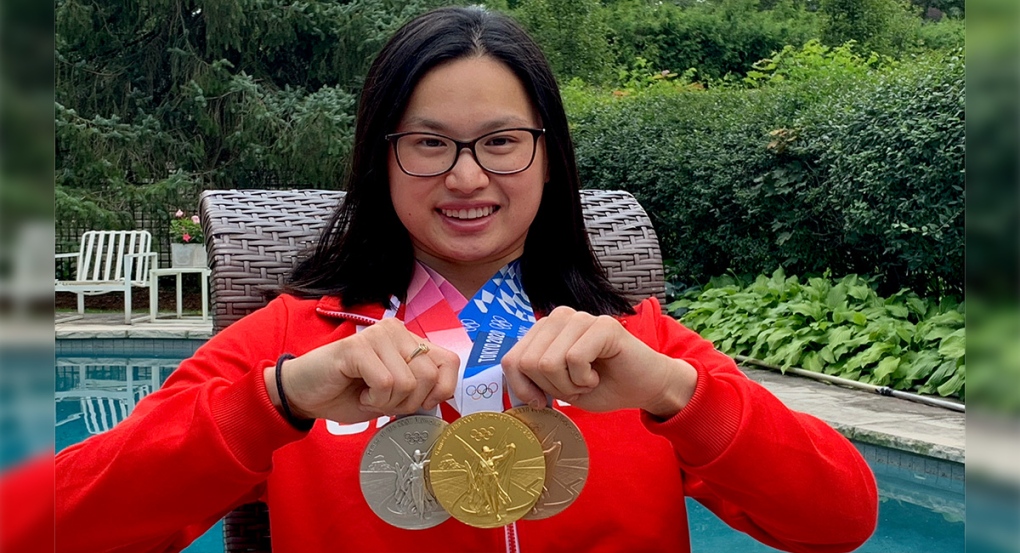 Maggie Mac Neil holds up her medals from the Tokyo Games back home in London, Ont. on Tuesday, Aug. 5, 2021. (Brent Lale / CTV News)