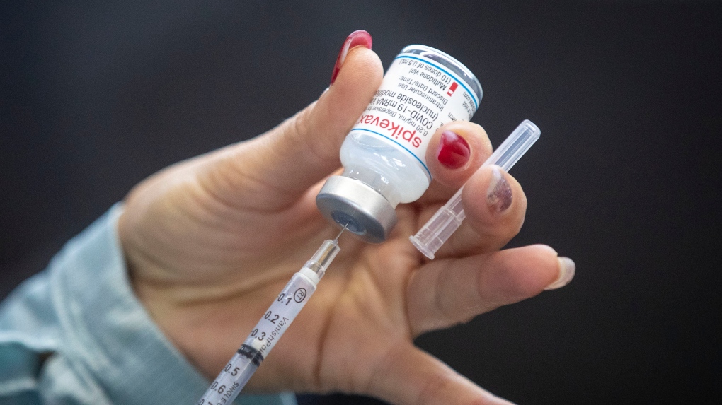 A person draws out Moderna vaccine during a drive through COVID-19 vaccine clinic at St. Lawrence College in Kingston, Ontario, on Sunday January 2, 2022. THE CANADIAN PRESS/Lars Hagberg