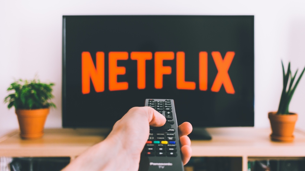 A person uses a remote control to watch Netflix. (Source: freestocks.org/Pexels) 