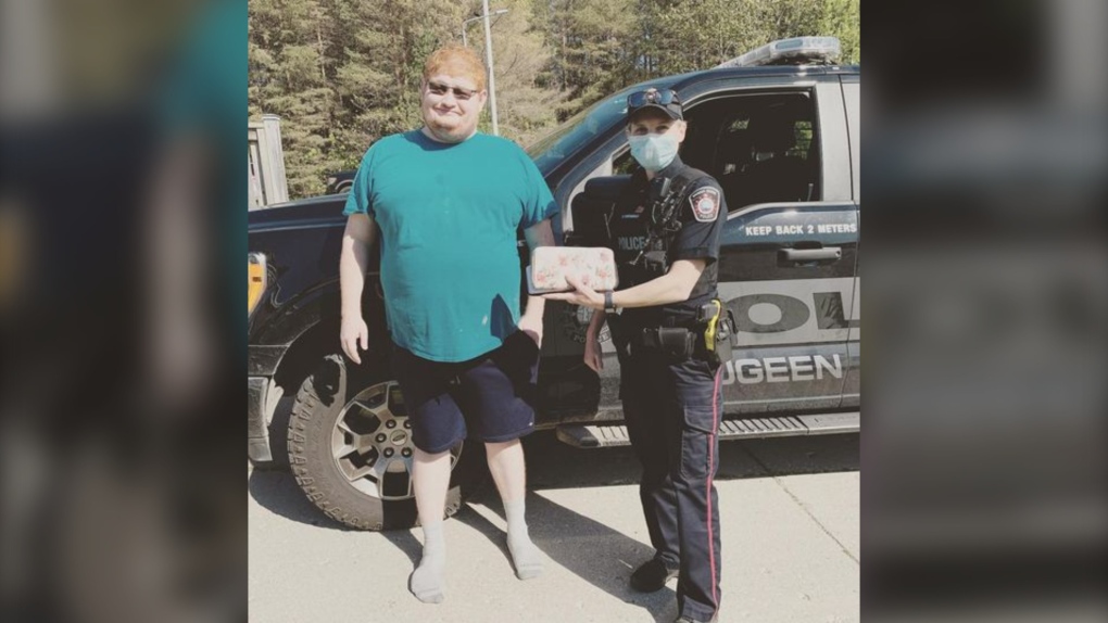 A Saugeen Shores police officer with a man named Jamie, who helped police return a lost cell phone and wallet containing $5,000 in cash to its rightful owner. (Saugeen Shores Police Service/Facebook)