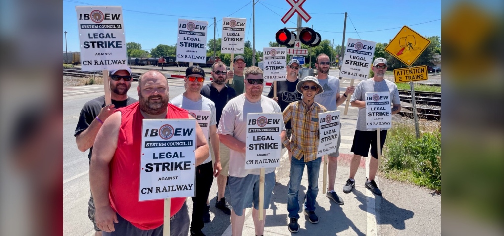 Striking CN workers are seen in front of a rail crossing in London, Ont. on June 21, 2022. (Sean Irvine/CTV London) 