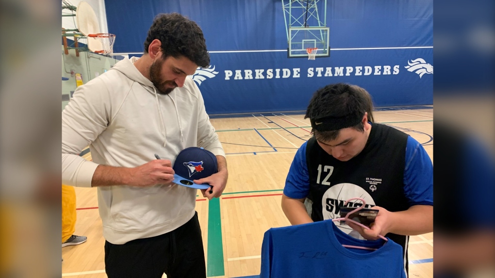 Toronto Blue Jays Pitcher Jordan Romano signs a hat for a local Special Olympian while in St. Thomas, Ont. for the St. Thomas Sports Spectacular on January 18, 2023. (Brent Lale/CTV News London)