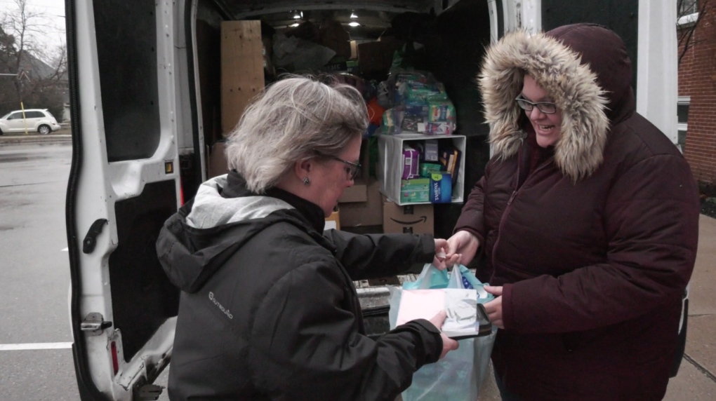 Andra Olevson (right) accepts a donation from Anne Smith-Bartolozzi (left) are seen in Lambeth, Ont. on March 25, 2023. (Bryan Bicknell/CTV News London)